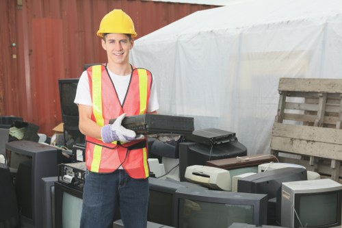 Segregated waste bins and labeled hazardous materials at a clearance site